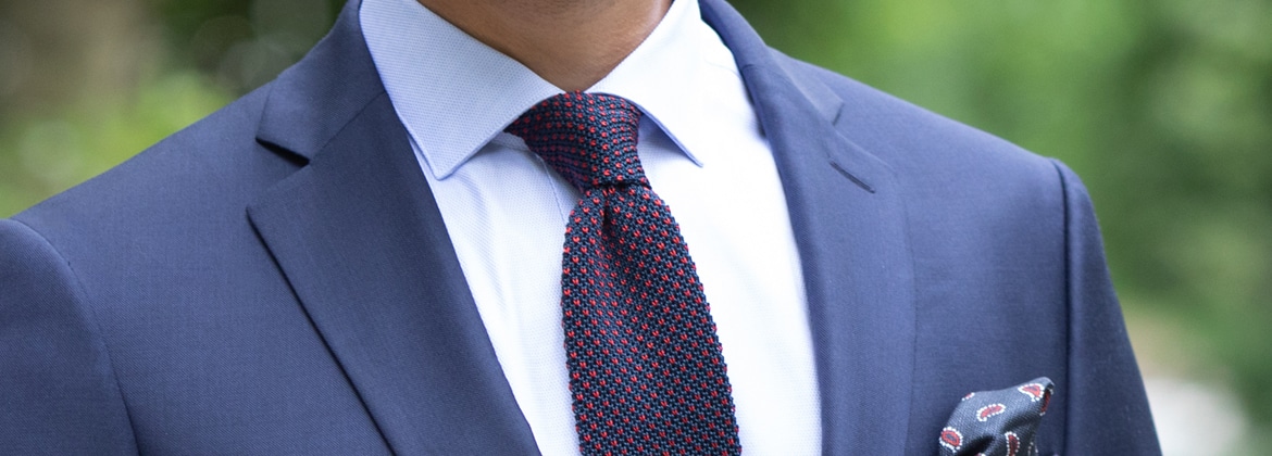 Photo of a patterned knit tie worn on a white shirt